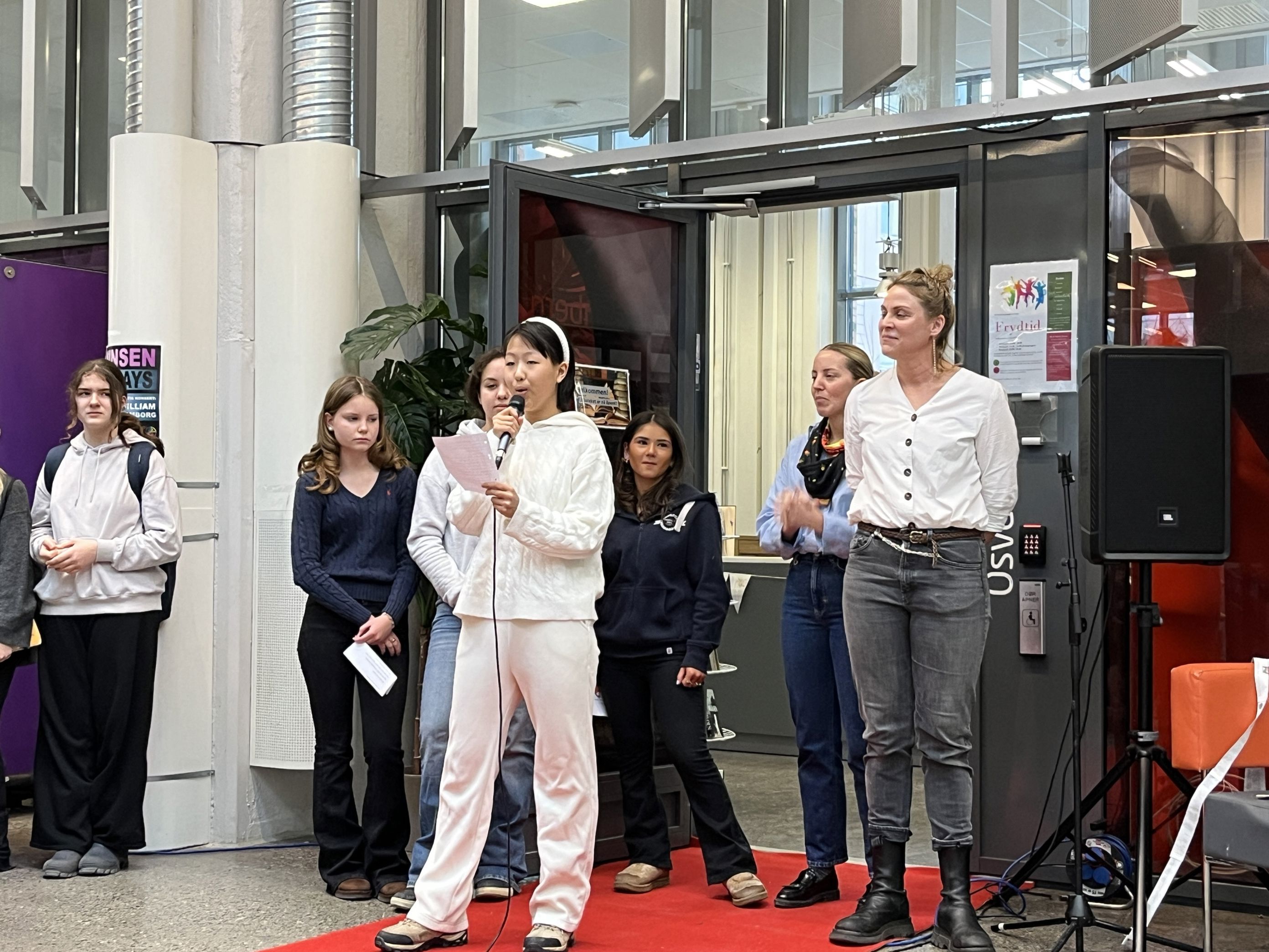 en gruppe mennesker som står foran en mikrofon